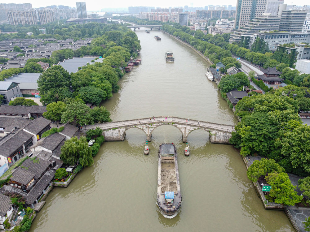 5月27日，一艘貨船駛過(guò)京杭大運(yùn)河南端標(biāo)志建筑杭州拱宸橋。(無(wú)人機(jī)照片)新華社記者江漢 攝