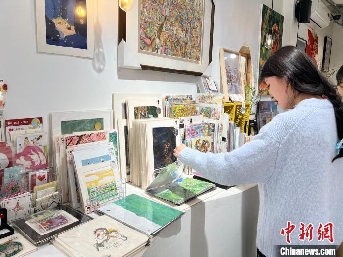 圖為藝術品商店內，顧客挑選插畫作品?！＄婌?攝