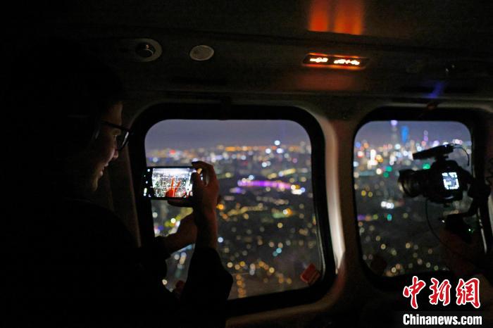 6月3日晚，游客乘坐上海新空直升機有限公司直升機開啟鳥瞰黃浦江空中圓夢之旅，并用手機拍攝城市夜景?！∫罅⑶?攝