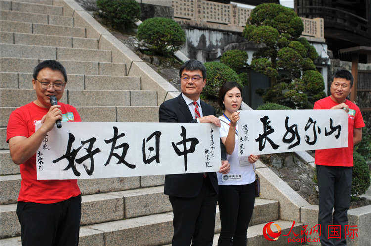 東京中國文化中心主任羅玉泉展示其為本次活動(dòng)書寫的題詞“中日友好，山高水長”。人民網(wǎng) 蔣曉辰攝