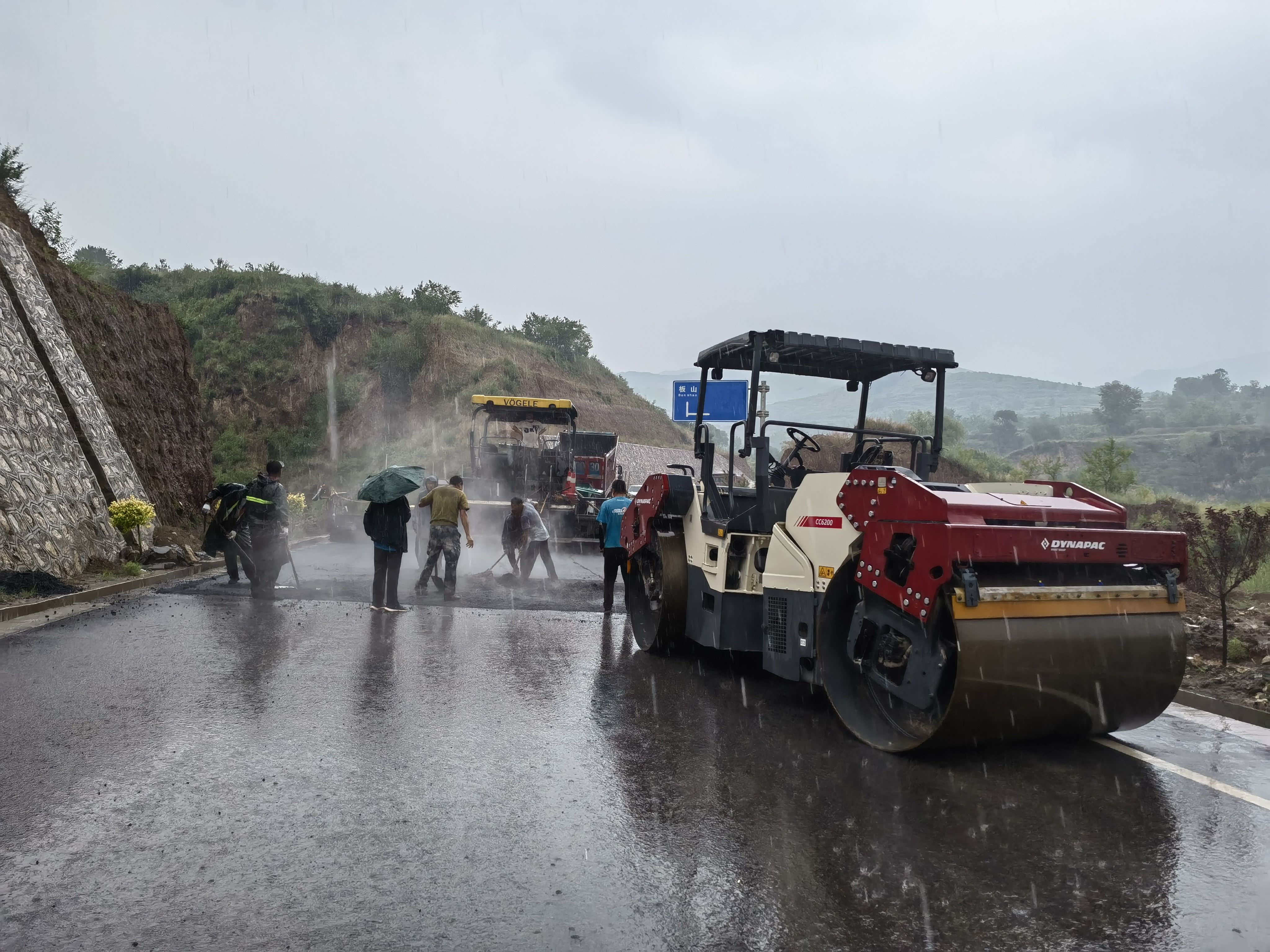 路橋工人在大雨中搶修道路。李華英 攝