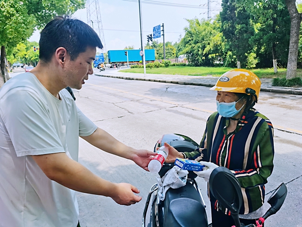 何超為過路的老人送上礦泉水和冷飲。人民網(wǎng)記者 王繼亮攝