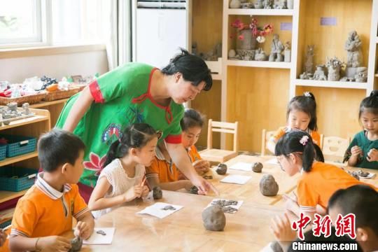 圖為劉雪玲正在給幼教中心的孩子上泥塑課?！＄娦?攝