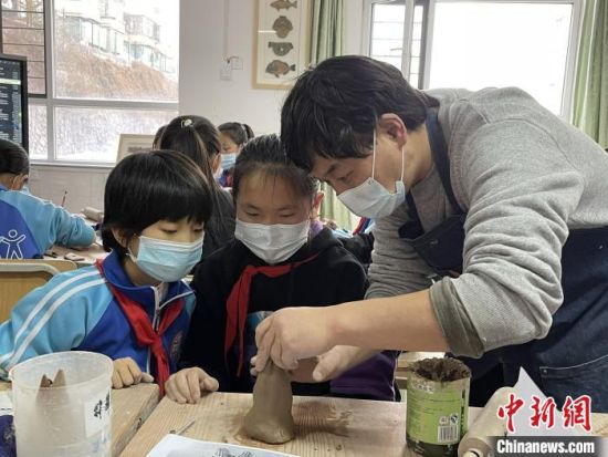 圖為西寧市勞動路小學教師賈煜與學生一起制作陶藝?！≈苋鸪阶?攝