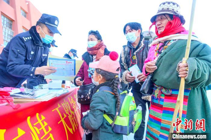 圖為拉薩鐵路公安民警向旅客發(fā)放乘車安全宣傳資料?！↑S飛 攝