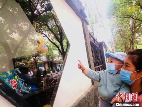 圖為蘭州市民在街頭觀賞刺繡和刻葫蘆的非遺展示。(資料圖) 史靜靜 攝