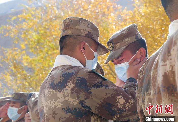 圖為什布奇邊防連退伍老兵與戰(zhàn)友相擁而泣，依依惜別。　徐昌成 攝