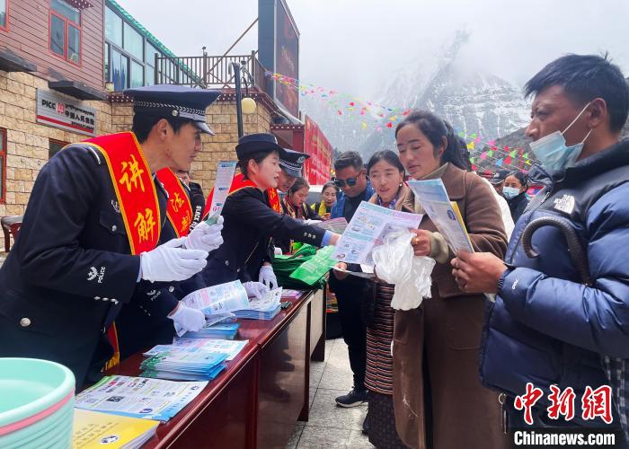 圖為山南玉麥邊境派出所民警為轄區(qū)群眾發(fā)放法律知識(shí)宣傳單?！＄婗?　攝