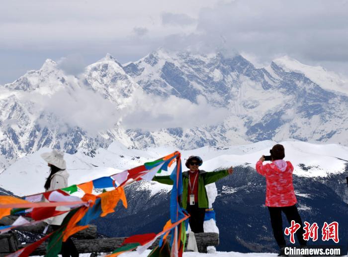 圖為5月14日，西藏林芝色季拉山觀景臺(tái)，游客與南迦巴瓦峰合影?！±盍?攝