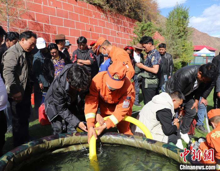 圖為森林消防員為護林員講解滅火裝備的使用方法?！〔际猩窒乐ш?供圖