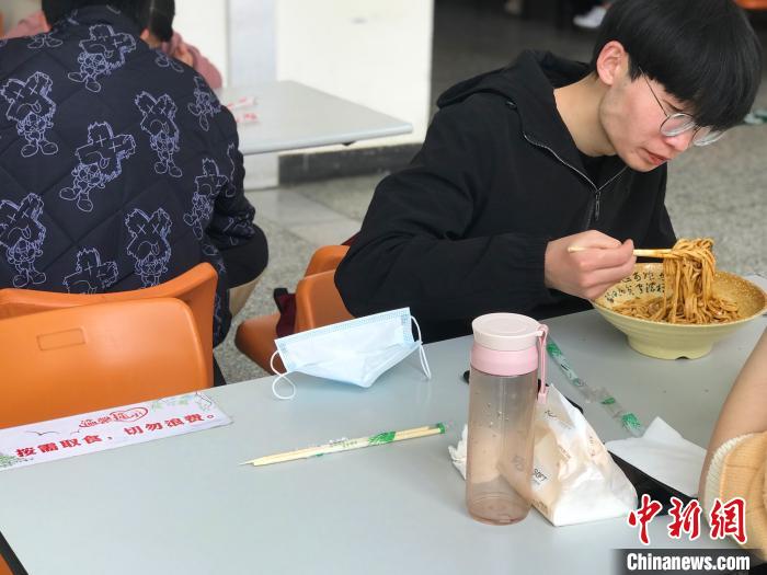 3月17日，西藏大學(xué)學(xué)生正在學(xué)校食堂用餐，餐桌上寫著“按需取餐，切勿浪費(fèi)”。　冉文娟 攝