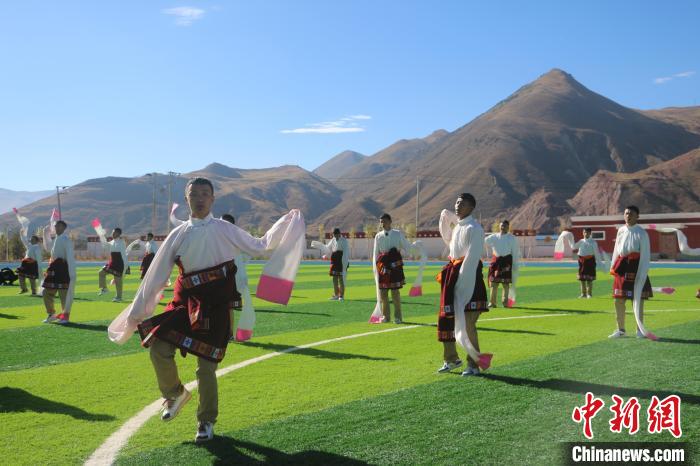 圖為青海師范大學(xué)附屬玉樹實驗學(xué)校學(xué)生在綠茵場跳起囊謙古舞—卓根瑪?！〕逃?攝