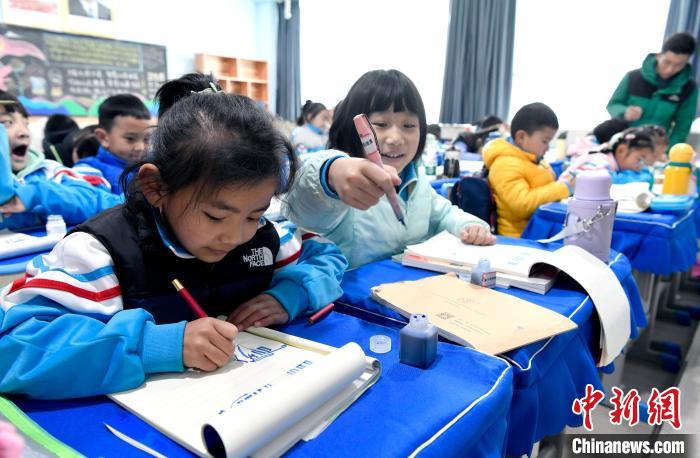 3月14日，西藏拉薩市第一小學一年級六班學生白瑪朗珍(圖左)在藏語文課上書寫藏文?！±盍?攝