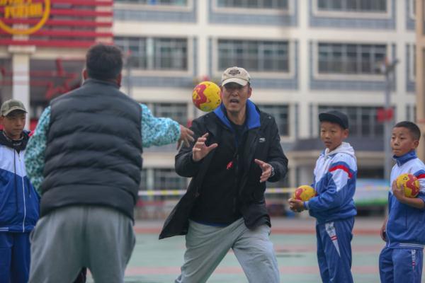 在高原上教孩子們打手球，“慢慢兒來，甭著急！”