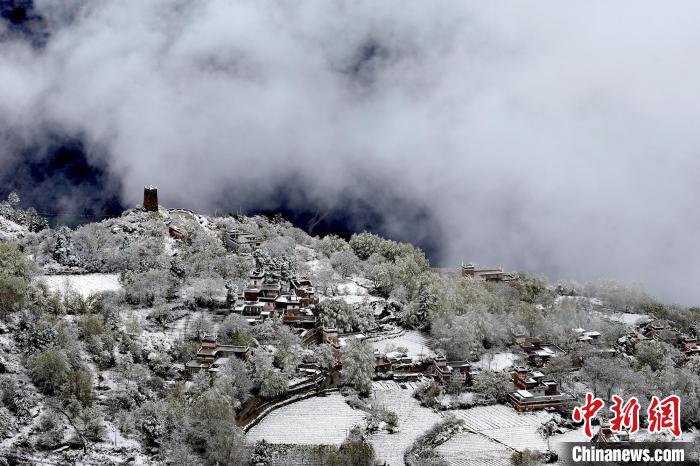 雪后的藏寨和碉樓構(gòu)成美麗的雪景?！〗党鯘衫?攝