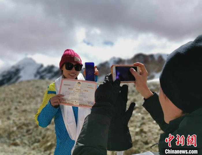 圖為5日，登頂洛堆峰的登山者獲得西藏自治區(qū)登山協(xié)會頒發(fā)的登頂證明?！垈?攝