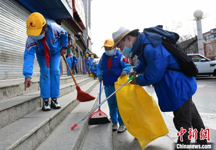 圖為拉薩市小學(xué)生打掃街道?！∝暩聛?lái)松 攝