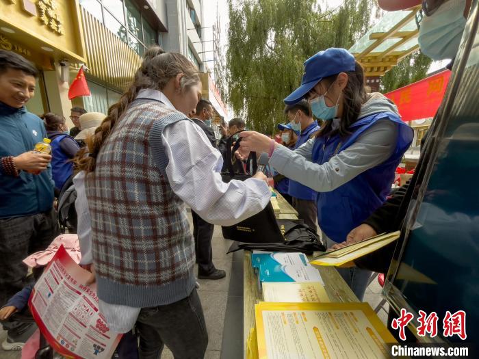 圖為志愿者為市民發(fā)放網(wǎng)絡(luò)安全宣傳手冊(cè)?！≈x牧 攝