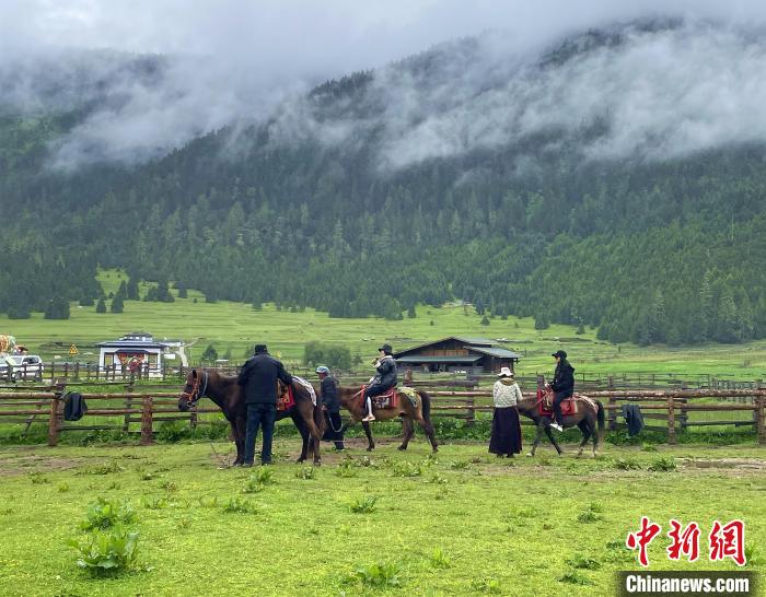 6月10日，游客在魯朗小鎮(zhèn)高山牧場(chǎng)景區(qū)體驗(yàn)騎馬。　冉文娟 攝