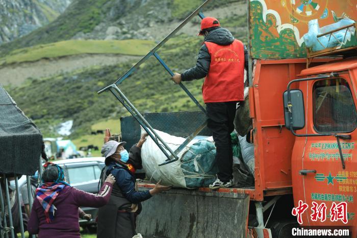 圖為工作人員幫助牧民們卸家具?！÷蹇?攝