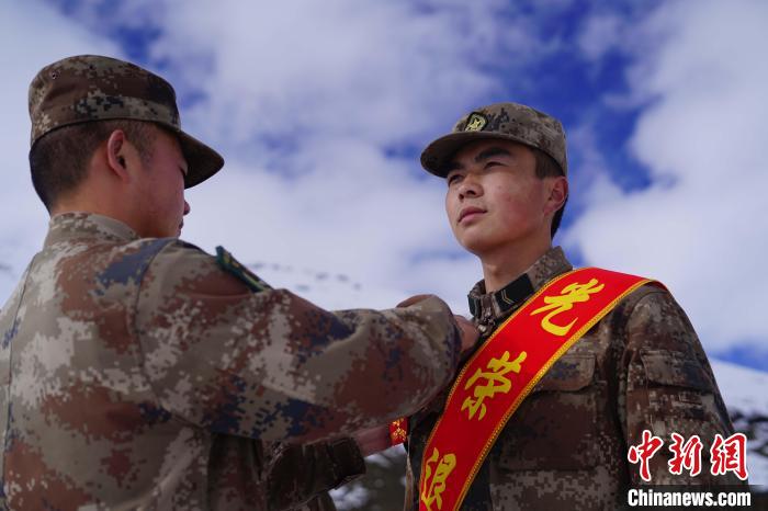 排長王朝偉(圖左)給退伍老兵佩戴大紅花。　西藏山南軍分區(qū)某團(tuán)供圖