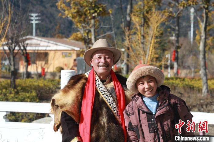 圖為林芝市巴宜區(qū)布久鄉(xiāng)仲果村村民桑杰與孫子一起參加藏歷新年活動。　張力 攝