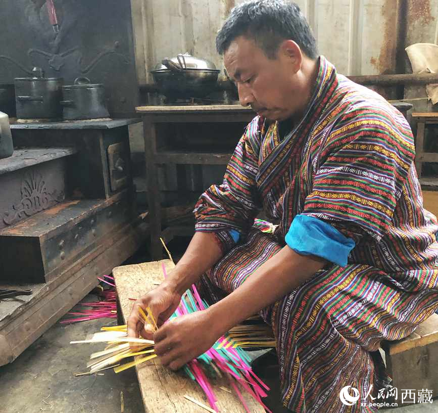 門巴族漢子愛明正在編織藤竹品。